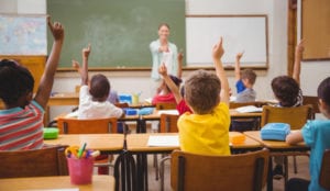 students raising their hands in class